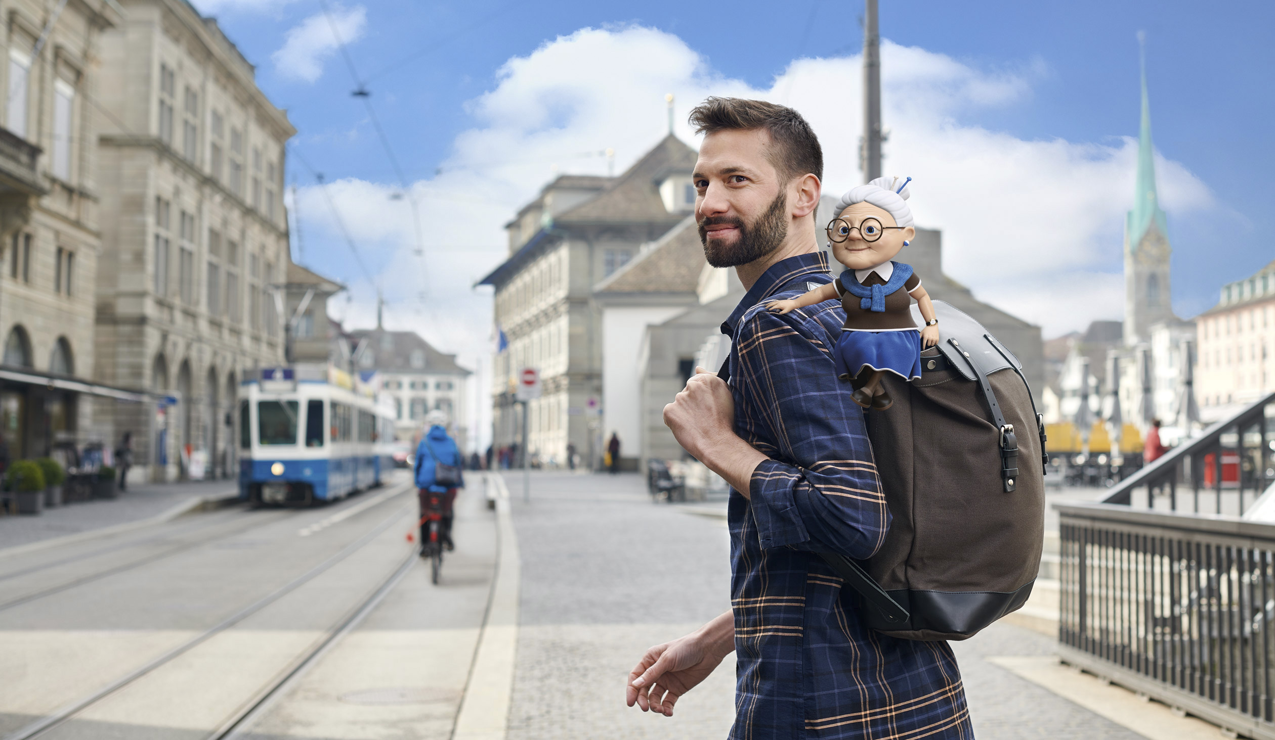 Beitragsbild Corporate, Werbefotografie, man überquert die strasse in Zürich, mit Grossmutter auf dem Rucksack